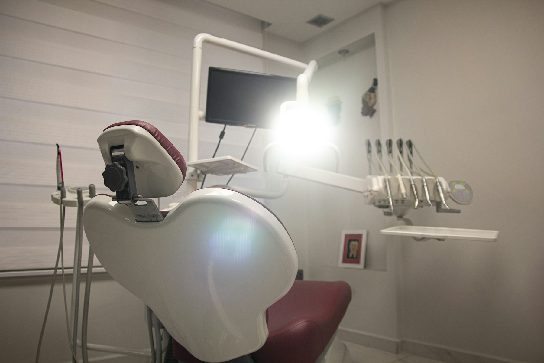 Salle de soins dentaires lumineuse, aux tons doux et bourgogne